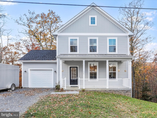 view of front property with a front lawn, covered porch, and a garage