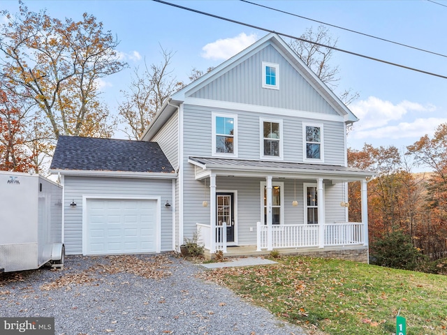 view of front of house with a front yard, covered porch, and a garage