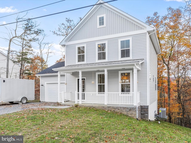 view of front of home with a front yard, central AC, covered porch, and a garage