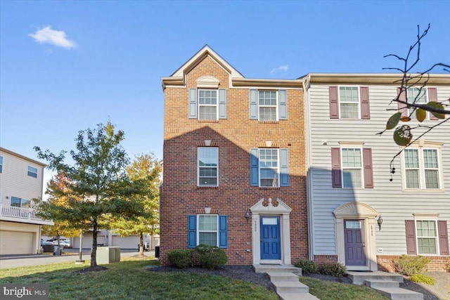 multi unit property featuring a front yard and a garage