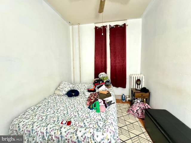 bedroom featuring radiator heating unit and ceiling fan