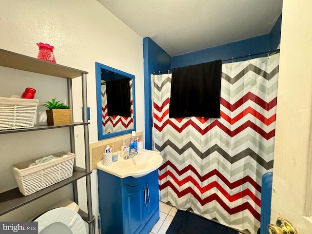 bathroom with a shower with curtain, vanity, and tile patterned floors