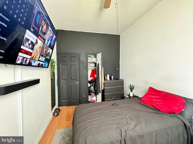 bedroom with ceiling fan, wood-type flooring, and lofted ceiling