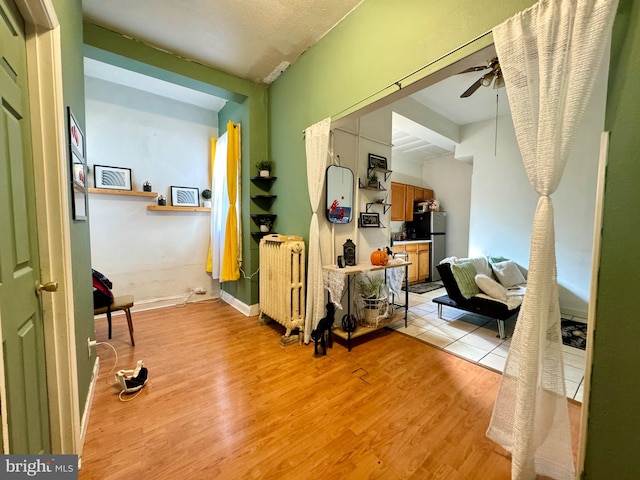 interior space featuring radiator heating unit and light hardwood / wood-style flooring