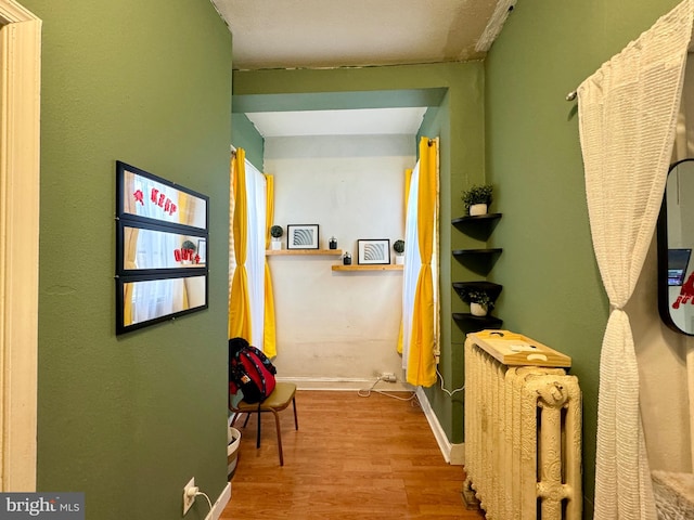 hall featuring hardwood / wood-style flooring and radiator