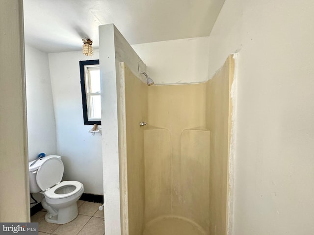 bathroom featuring a shower, tile patterned flooring, and toilet