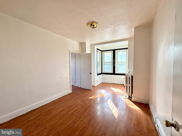 spare room with light hardwood / wood-style floors and radiator