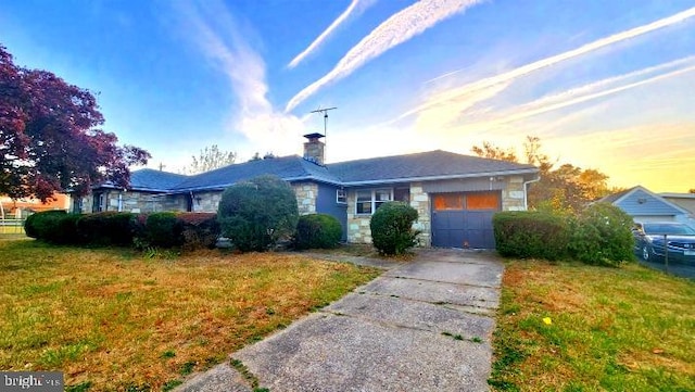 ranch-style home with a lawn and a garage