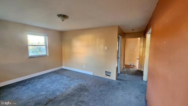 spare room with dark colored carpet