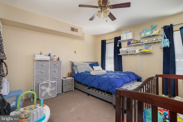 carpeted bedroom with ceiling fan and visible vents