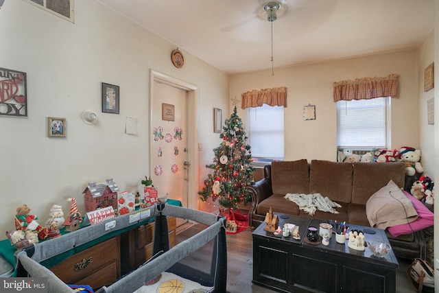 living room with dark hardwood / wood-style flooring and ceiling fan