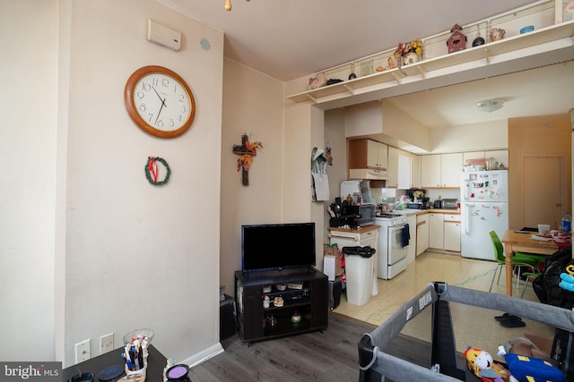 kitchen with white cabinets, white appliances, and light hardwood / wood-style floors