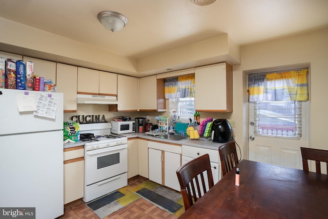 kitchen featuring white appliances, sink, and dark parquet flooring