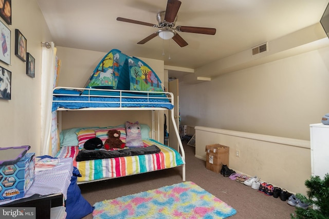 carpeted bedroom with a ceiling fan and visible vents