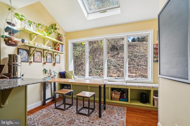 interior space with hardwood / wood-style floors and lofted ceiling with skylight