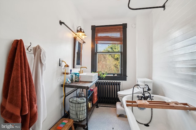 bathroom featuring radiator, wood walls, sink, tile patterned flooring, and a washtub