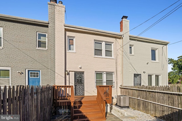 rear view of house with a wooden deck and central air condition unit