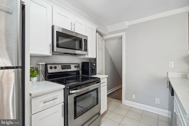 kitchen with crown molding, white cabinets, stainless steel appliances, and light tile patterned floors