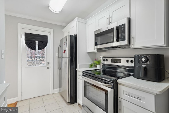 kitchen featuring ornamental molding, light tile patterned flooring, white cabinetry, and stainless steel appliances