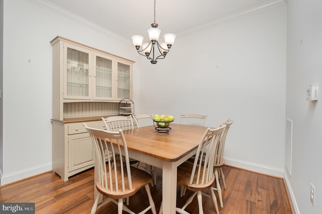 dining room with ornamental molding, light hardwood / wood-style floors, and a notable chandelier