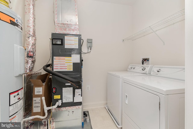 laundry room featuring electric water heater and separate washer and dryer