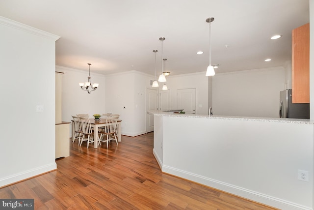 kitchen with hardwood / wood-style flooring, stainless steel refrigerator, light stone countertops, decorative light fixtures, and crown molding