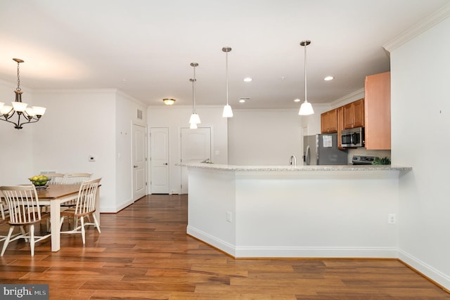 kitchen with stainless steel appliances, kitchen peninsula, hardwood / wood-style flooring, ornamental molding, and light stone countertops