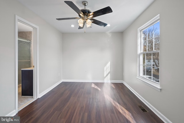 unfurnished room with ceiling fan and dark hardwood / wood-style flooring