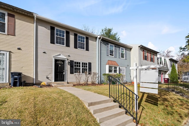 townhome / multi-family property featuring a front lawn