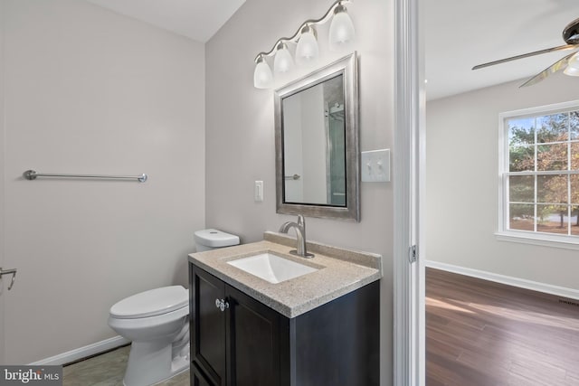 bathroom with hardwood / wood-style flooring, vanity, ceiling fan, and toilet