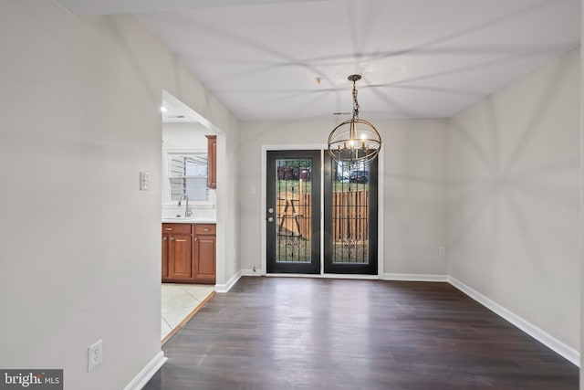 foyer entrance featuring sink, dark hardwood / wood-style flooring, and a notable chandelier