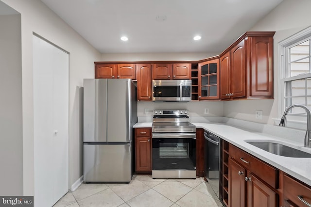 kitchen with light tile patterned floors, stainless steel appliances, and sink