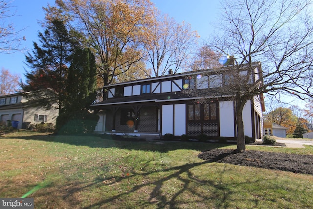 back of property featuring a lawn and a garage