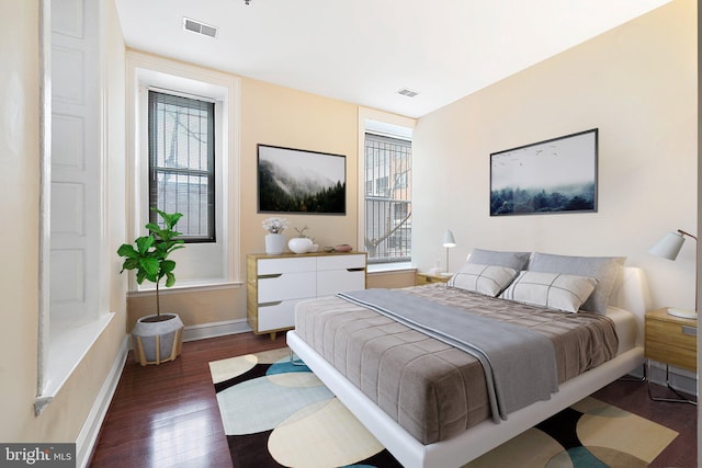 bedroom featuring multiple windows and dark hardwood / wood-style floors