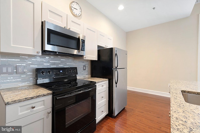 kitchen featuring dark wood-type flooring, backsplash, appliances with stainless steel finishes, and white cabinets