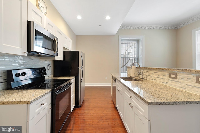 kitchen featuring appliances with stainless steel finishes, white cabinets, and sink