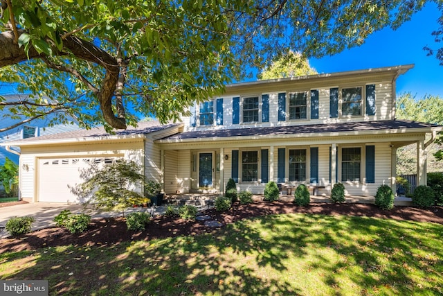 view of front of property with an attached garage, driveway, a porch, and a front lawn