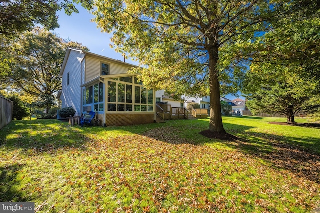 view of yard with a sunroom and fence