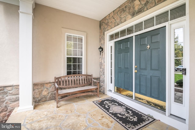 view of exterior entry featuring covered porch