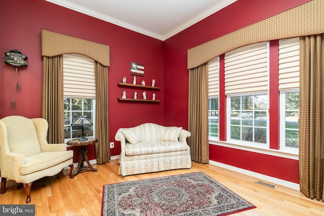 sitting room featuring hardwood / wood-style floors and crown molding