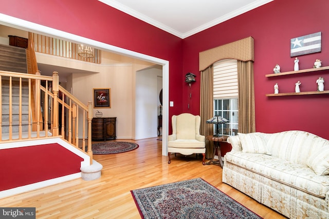 living room with hardwood / wood-style flooring, a chandelier, and ornamental molding