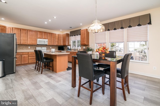 dining room featuring a wealth of natural light, a chandelier, and sink