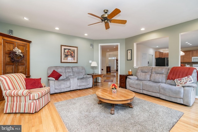 living room featuring wood-type flooring and ceiling fan