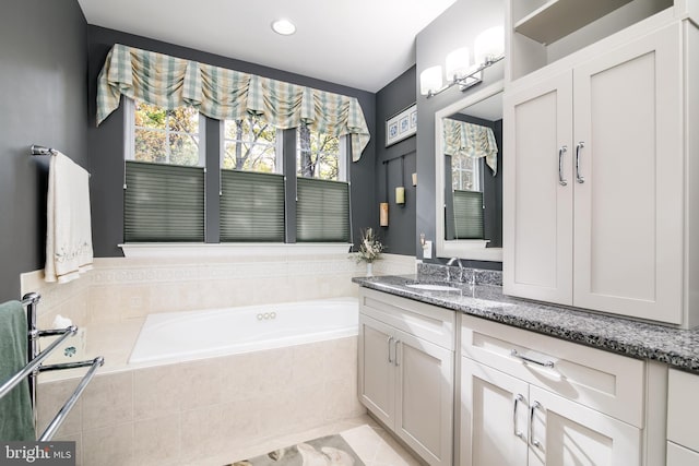 bathroom with tiled bath, tile patterned flooring, and vanity