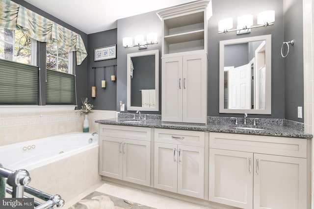 bathroom featuring vanity, tiled tub, and tile patterned floors