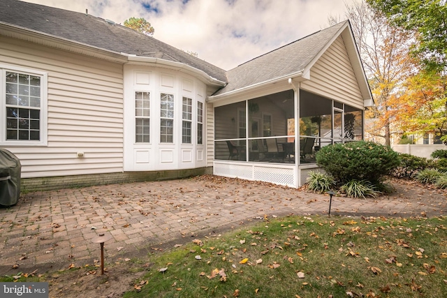 view of side of home with a patio area and a sunroom