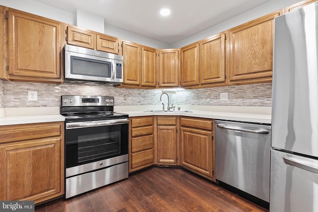 kitchen featuring sink, dark wood-type flooring, tasteful backsplash, and appliances with stainless steel finishes