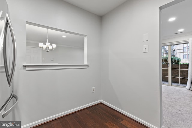 unfurnished dining area with a notable chandelier, ornamental molding, and hardwood / wood-style flooring