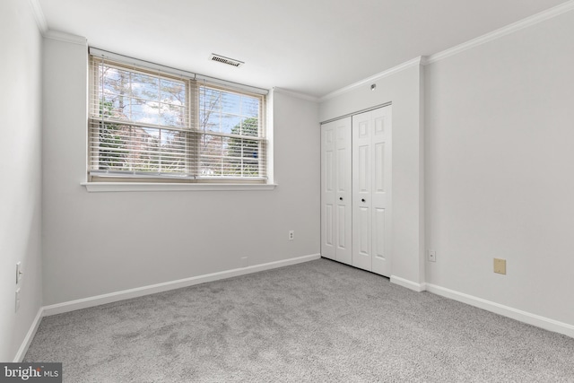 unfurnished bedroom featuring light colored carpet, a closet, and crown molding