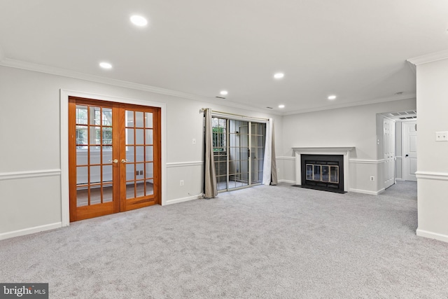 unfurnished living room with french doors, crown molding, and light colored carpet